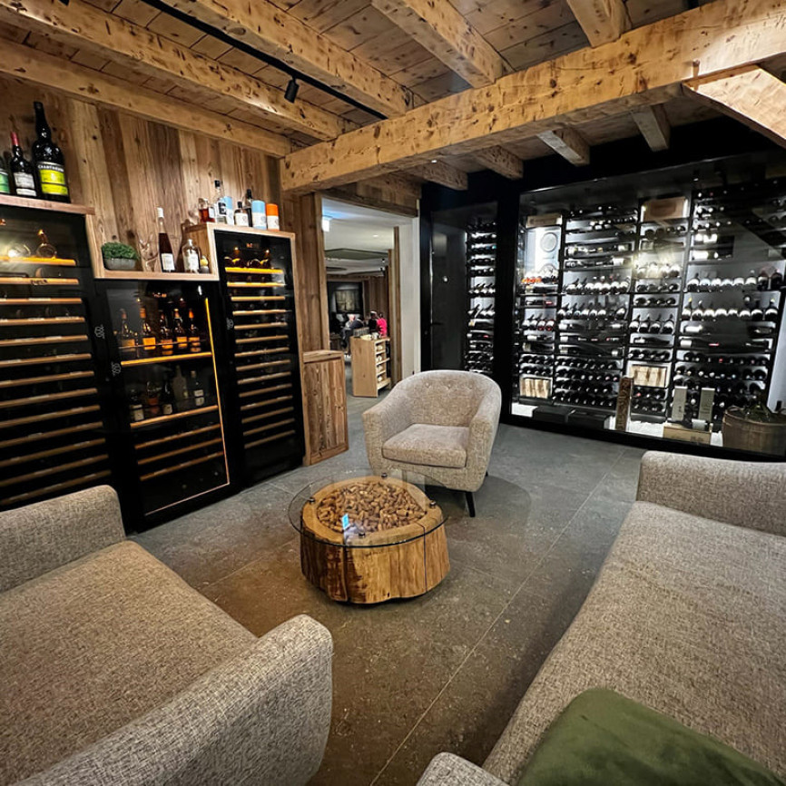 Design restaurant – Aménagement d’un meuble mural avec 3 caves a vin intégrées et d’une vitrine à vin climatisée avec des rangements vin métal noir aériens. Modulo-X