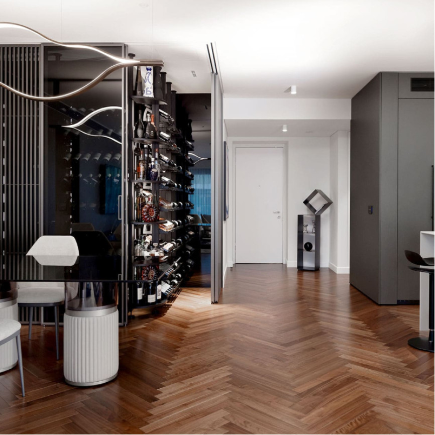 Glazed and air-conditioned wine cellar showcase in a dining room with open kitchen in a luxury flat. Modulo-X EuroCave metal wine storage unit