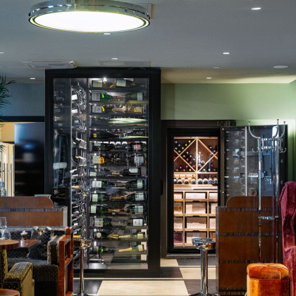 Cave de présentation vitrée et étagères en métal noir Modulo-X au restaurant Sommerro House, Norvège.