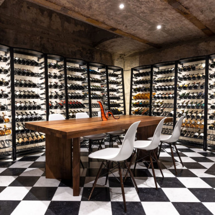 Aménagement d'une "Wine Room" avec rangement mural en métal Modulosteel et sol à damier.