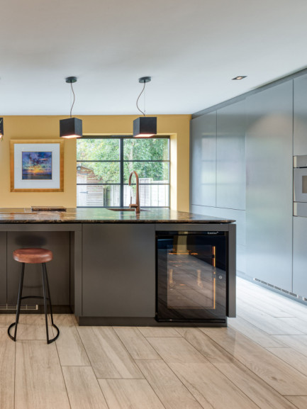 Small built-in wine cooler in an open-plan kitchen with a glass-front door